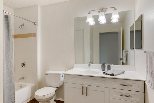 Renovated Package I bath with white cabinetry and hard surface plank flooring