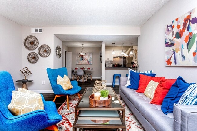 Bright open-concept living room with modern furnishings and gray sofa.