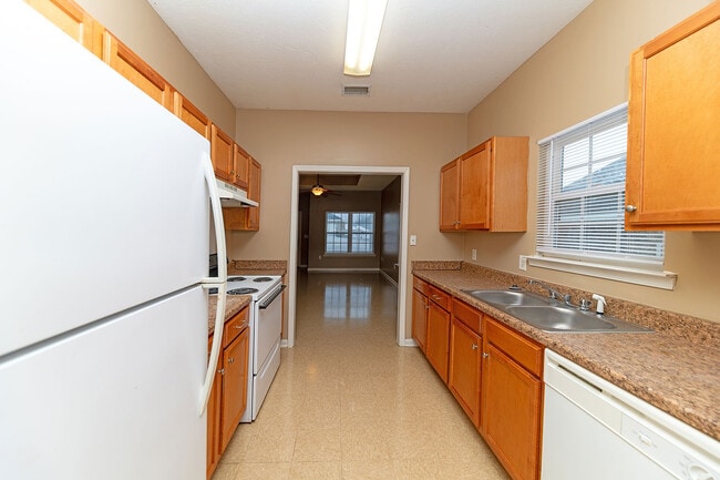 Kitchen with white appliances, wooden cabinetry, and generous counterspace