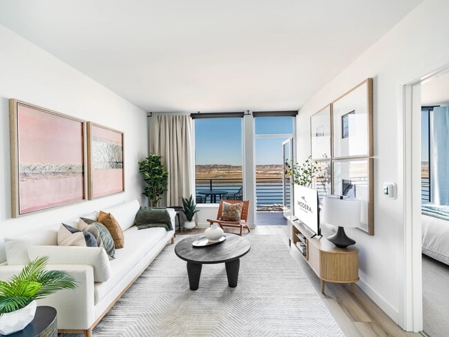 Open living with clean finishes, soft light, and direct access to a private balcony. - Modera Revere Beach