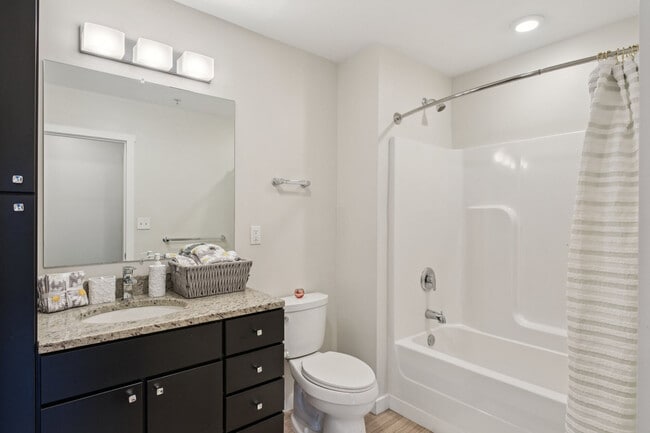 Baño de apartamento con tocador de doble lavabo y acabados contemporáneos.