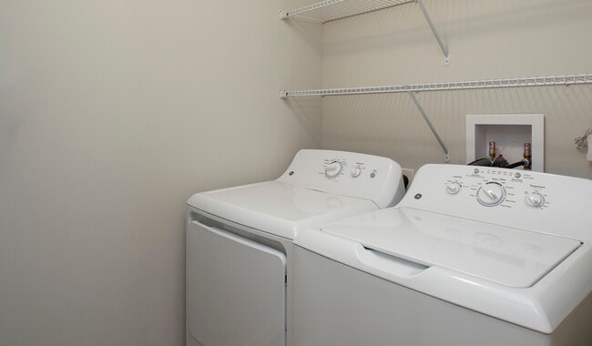 Laundry room with chalkboard wall and storage space in select units