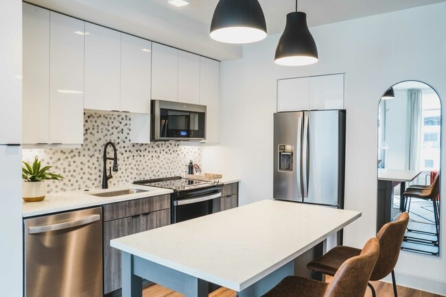 Quartz kitchen countertop with custom 42 inch cabinets - Modera Gulch Apartments