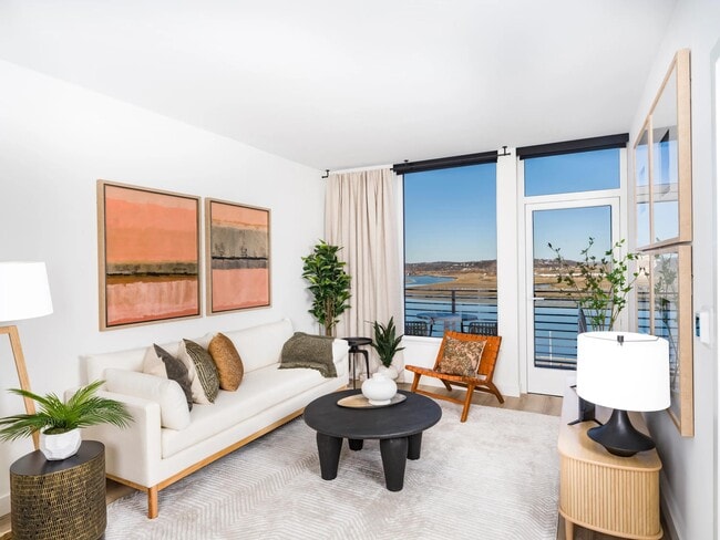 A bright living space with water views, warm finishes, and a seamless connection to your private balcony.