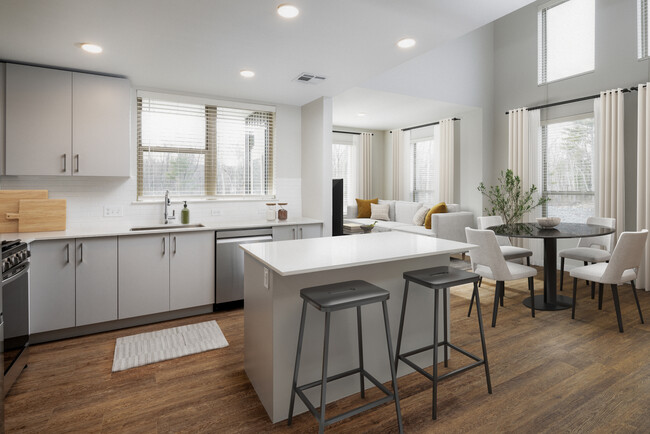 Kitchen with stainless steel appliances, white quartz countertop, light grey cabinetry, and hard surface flooring - Kanso Milford Apartments