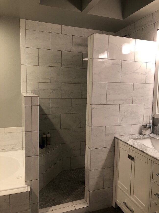 fully remodeled master bathroom with granite and tile and sky light. - 9915 NE 124th St Townhome