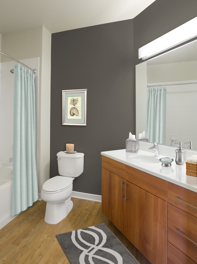 Upgraded bath with walnut cabinetry, white quartz countertop and hard surface flooring