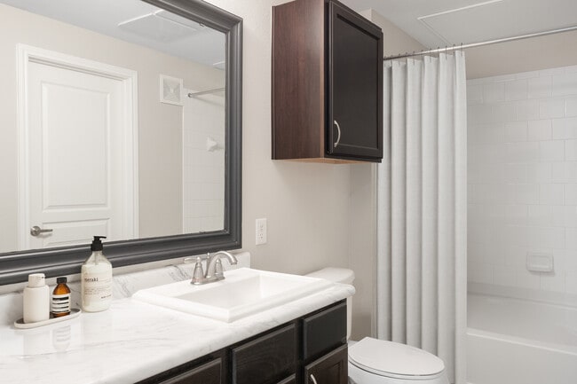 Bath with espresso cabinetry, quartz or granite countertop, and hard surface vinyl plank flooring