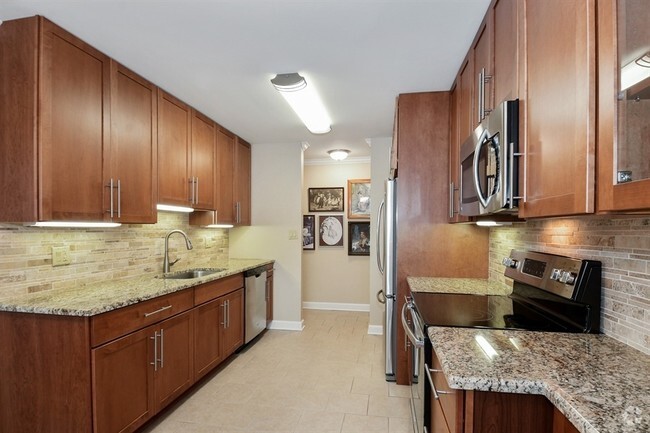 Spacious  kitchen with Cherry Cabinets, Granite Countertops and Stainless Steel Appliances - Americana Apartments