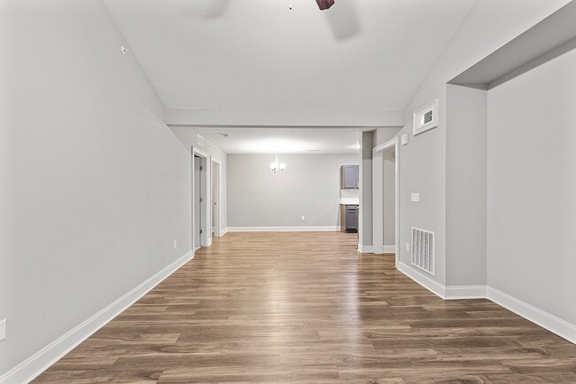 Spacious open-plan living area with sleek hardwood floors and elegant neutral tones. - Grove Park
