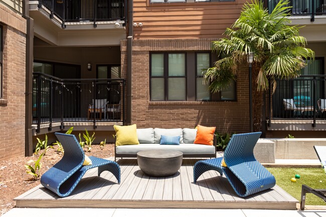 A raised deck off the lawn, set up for conversation rather than sun.