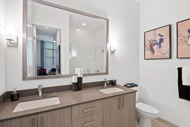 Bath with dual sink vanity, grey quartz countertops and hard-surface vinyl plank flooring