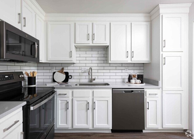 Modern kitchen with slate appliances and white cabinetry - Hurstbourne Grand Apartments