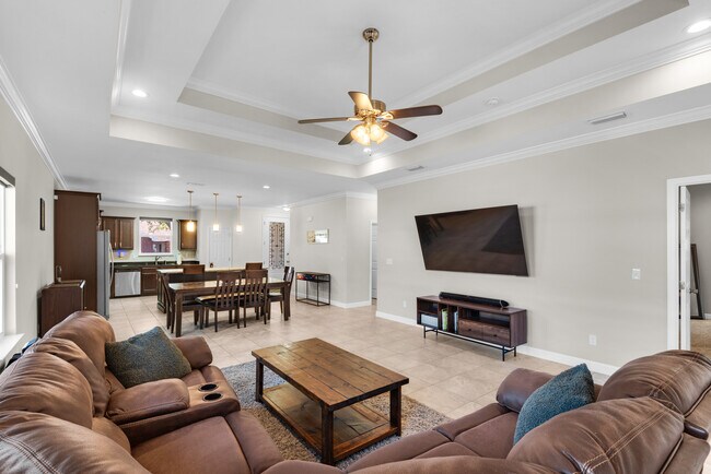 Living room has a huge TV, surround sound, blackout shades, and huge couch