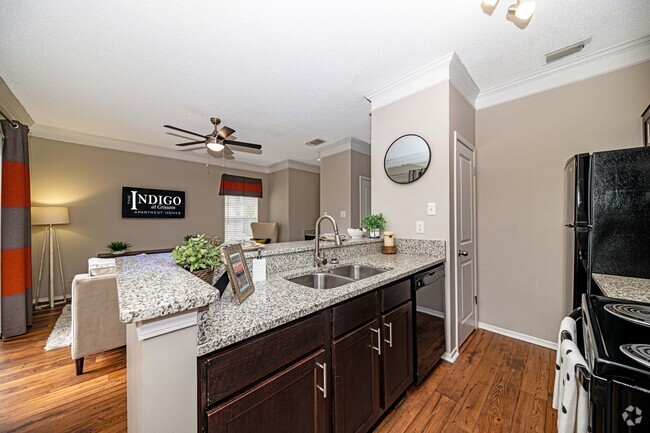 Kitchen with granite counters and black appliances - The Indigo at Grissom Rental