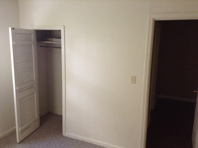 Second bedroom with smaller closet to the left and hallway to the right. The bathroom is behind the closet. - 24 N K St Casa