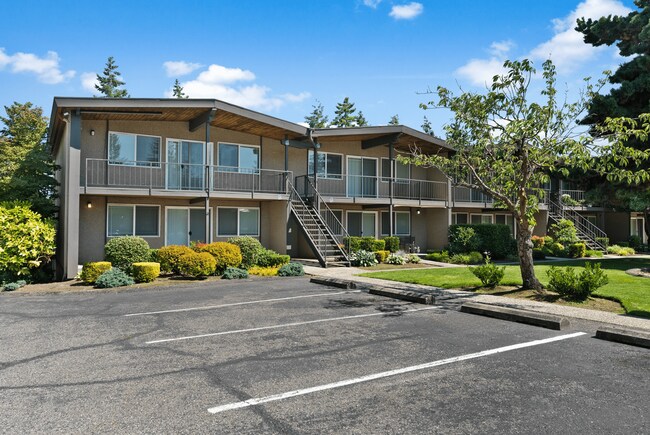 Charming two-story apartment building with lush landscaping and convenient parking.