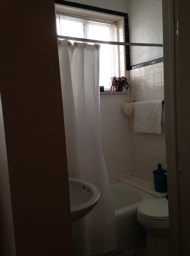 Bathroom with tub and back & white ceramic tiles - 1243 S 22nd St Unit Apt 2