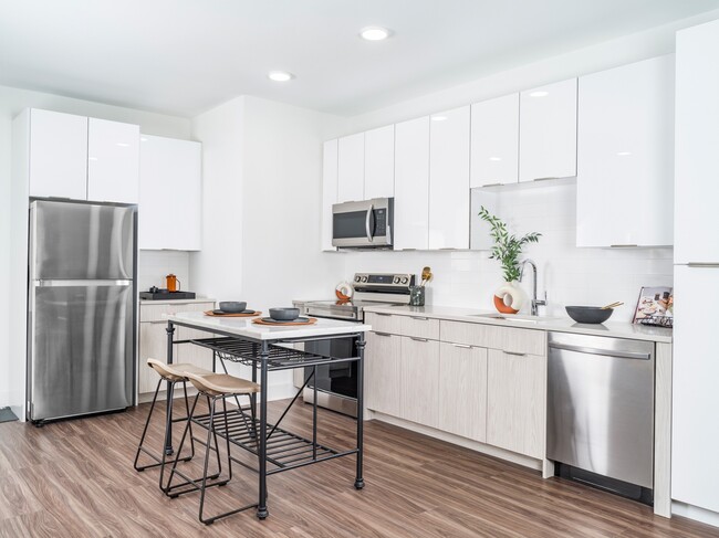 Alluring kitchens feature quartz countertops, charming tile backsplashes, and custom-built 42-inch cabinetry. - Modera Montville Apartments