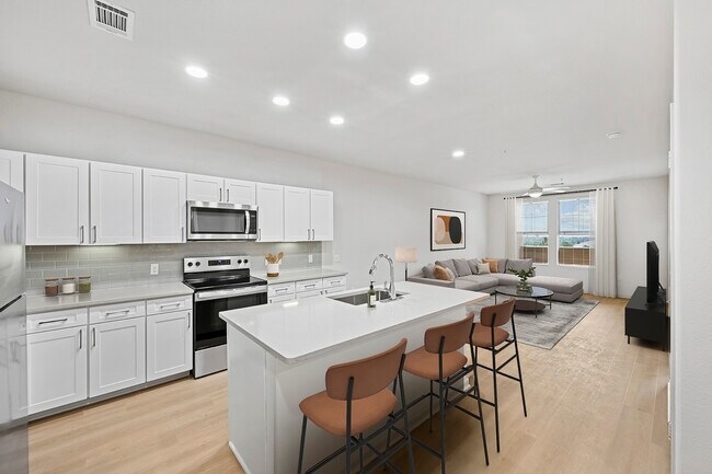 Renovated Package I kitchen with white cabinetry, grey quartz countertops, grey subway tile backsplash, stainless steel appliances, and hard surface flooring