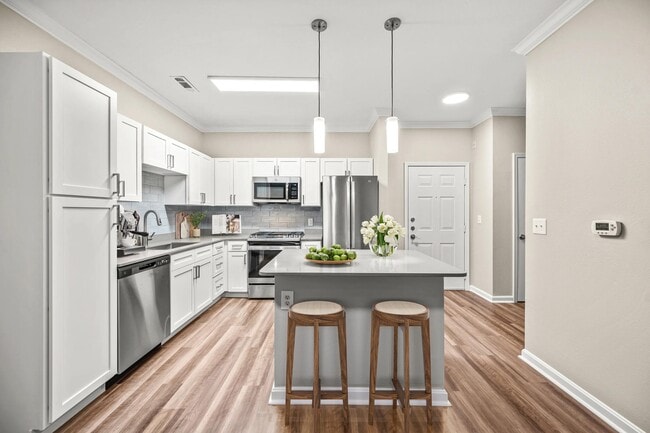 Kitchen with a central island, stainless steel appliances, and bright cabinetry, creating a functional space for cooking, dining, and everyday connection.