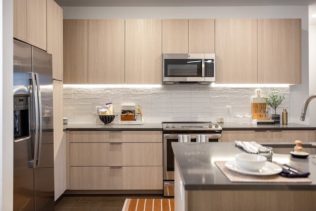 Modern kitchen with sleek finishes and stainless steel appliances. - The Allison at Fenton Rental