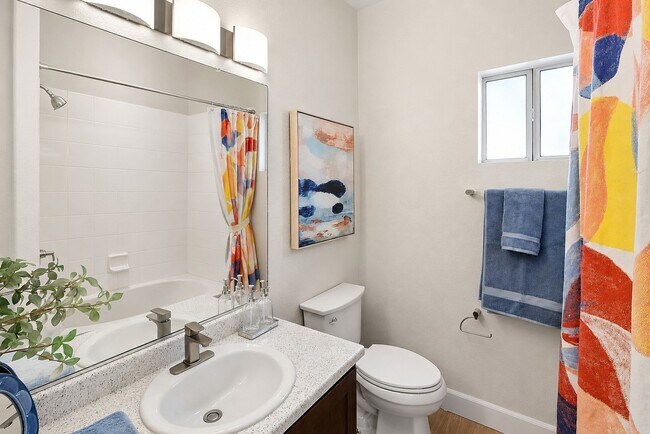 Step into the stylish bathroom at Serena Shores, featuring modern fixtures and vibrant decor. This serene space combines comfort and elegance, perfect for unwinding after a long day. Explore your future home today!