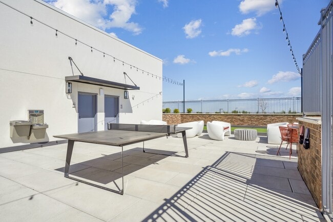 Salón en la azotea con mesa de ping pong y zona de parrilla