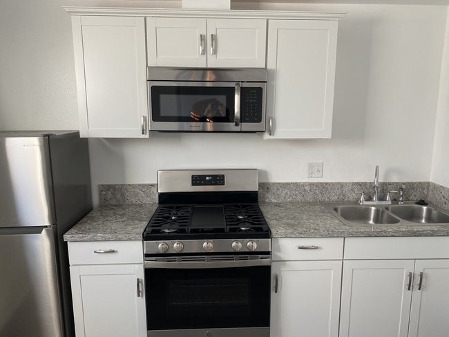 Studio kitchen features granite counter tops, full gas range, microwave, and fridge. - 1911 W 94th St Casa
