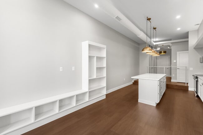 Living area with built in shelves looking into kitchen