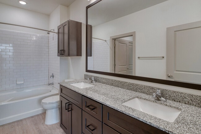 Modern Oakwood Trails - A 62+ Affordable Community in Spring, TX bathroom with a large mirror, sleek vanity, and bright lighting for a fresh, contemporary look.