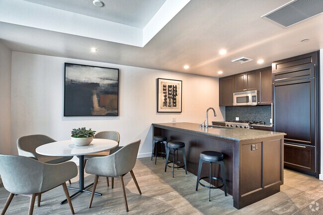 City Home kitchen featuring granite countertops and espresso cabinetry - The Bravern Rental