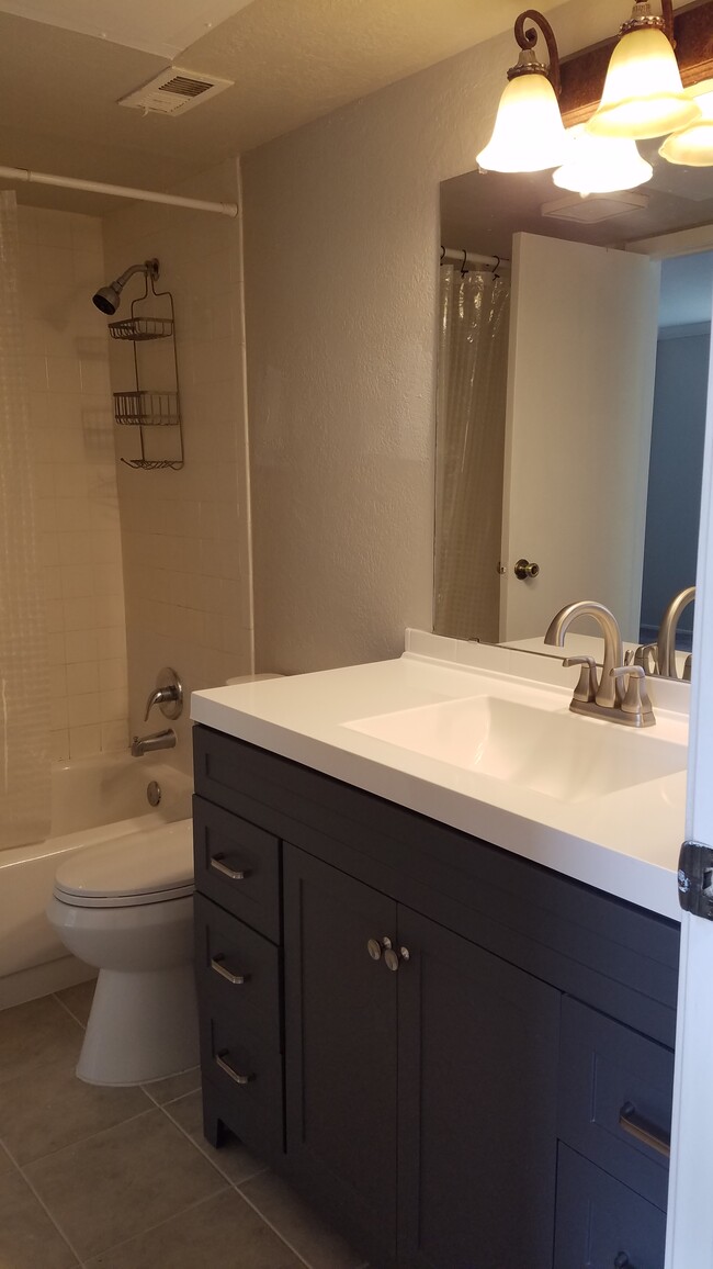 Baño renovado con nuevo tocador alto y pisos de baldosas. - 14777 Wunderlich Dr Unidad #1705