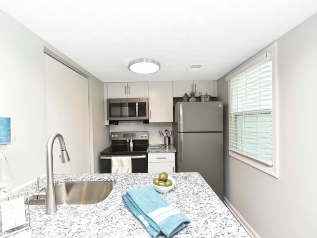Kitchen with granite counters, modern cabinetry, and stainless appliances