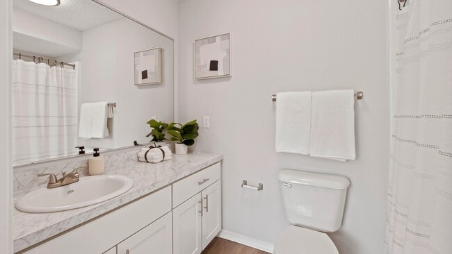 Rediscover luxury in our luxe bathrooms. Admire expansive White Carrara countertops, wood-style flooring, and a generously sized mirror.