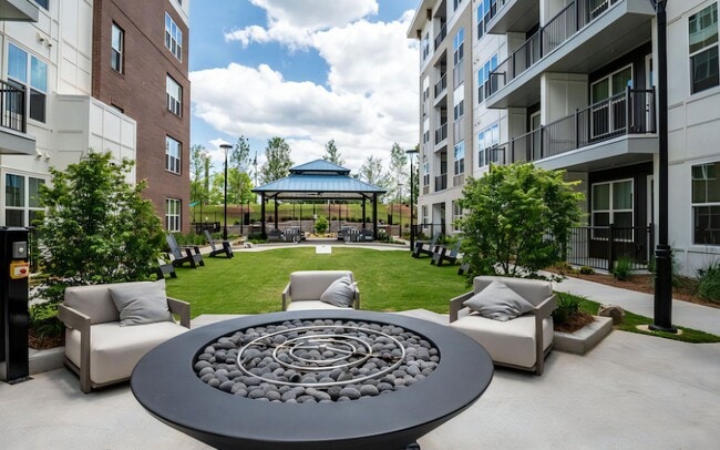 Open Courtyard with Grass Lawn, Fire Pit, and Outdoor Furniture - The Elden Galleria