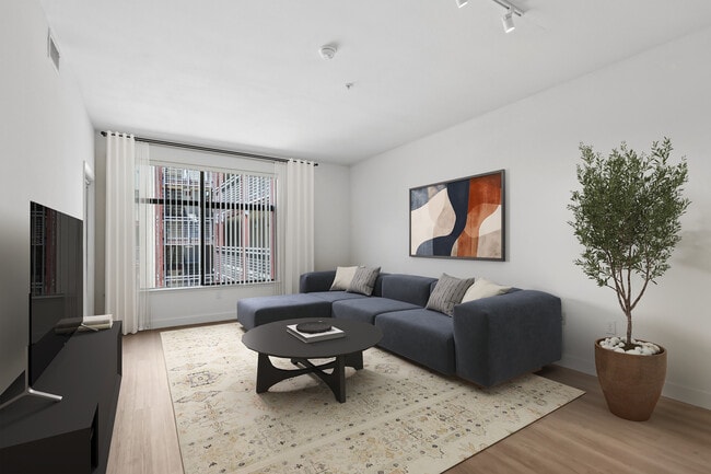 Renovated Package II living room with hard surface flooring - Avalon at Cahill Park