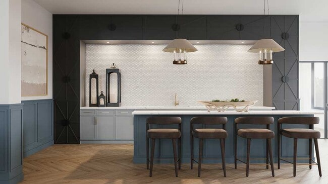 Elegante área de bar comunitario con gabinetes azules, encimeras de cuarzo, iluminación colgante y asientos de bar diseñados para reuniones sociales. - Mesquite Trails at Brooks