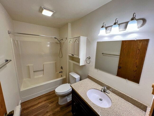 bathroom featuring a full tub/shower combo, large mirror, and plenty of vanity storage - 213 Ash Street