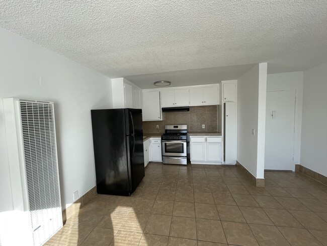 Cocina y entrada de un dormitorio. - 1513 S Arlington Ave Apartamentos