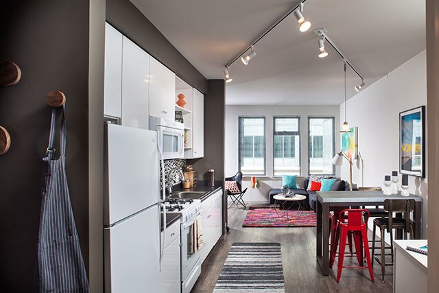 Classic Package I kitchen with white appliances, dark laminate countertops, white cabinetry, tile backsplash, and hard surface flooring