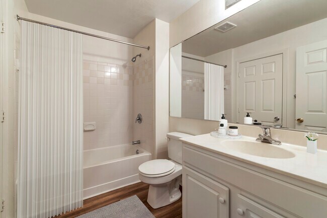 Renovated Package II bath with white cabinetry, white granite countertops, and hard surface plank flooring