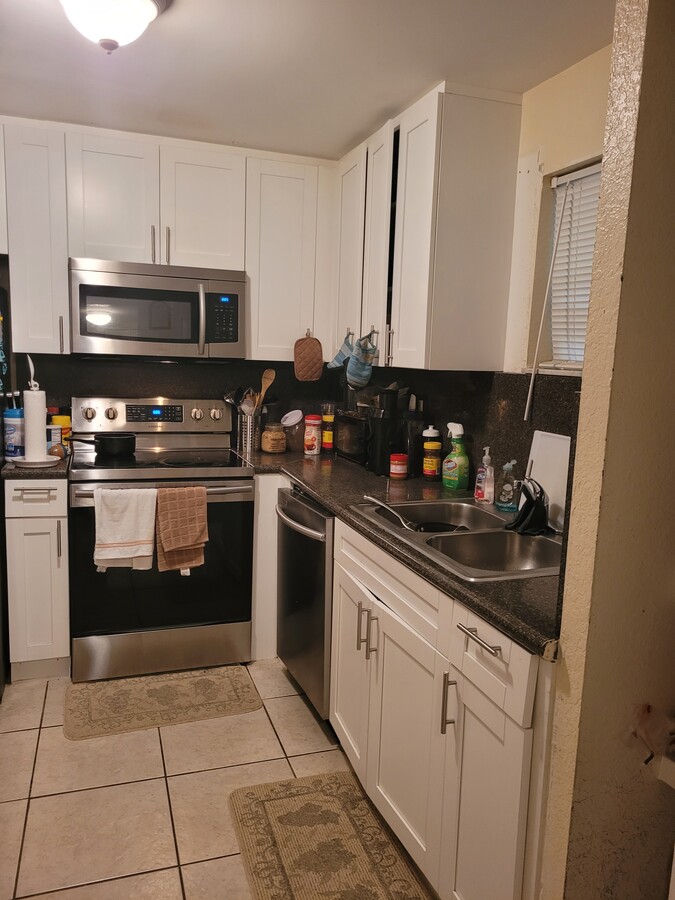 Kitchen with full shaker cabinets and stainless steel appliances - 4215 N University Dr Condo Unit 101