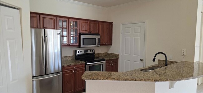 Kitchen with granite counter tops and laundry closet - 3707 Conroy Rd Unit 1722