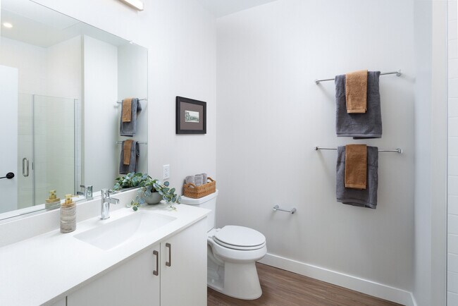 Design Collection I bath with white quartz countertop, white cabinetry, standing shower, and hard surface flooring
