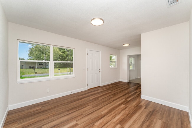 Luminosa sala de estar con pisos nuevos y un diseño abierto que le da la bienvenida al entrar. - 2924 Bellwood Ave