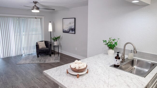 Enjoy an open living space that extends to your private patio or balcony through sliding glass doors, offering natural light and a seamless indoor-outdoor flow. Perfect for relaxation and entertaining. - POSTE Winter Park