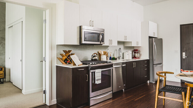 Well appointed kitchen featuring espresso lower cabinetry and white upper cabinetry - Blossom Plaza Rental