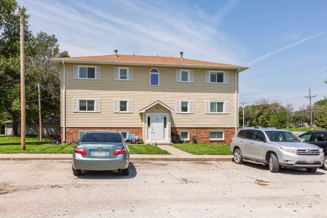 Parking lot and front exterior of Ashland Park Apartments.