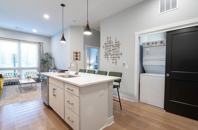 Quarry Trails Model washer/dryer, island kitchen and living room - Tillmore at Quarry Trails Apartments